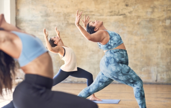 Three people in workout clothes doing yoga