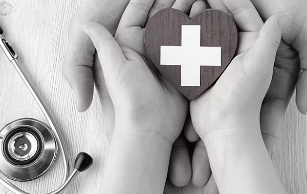 small hands holding a first aid symbol