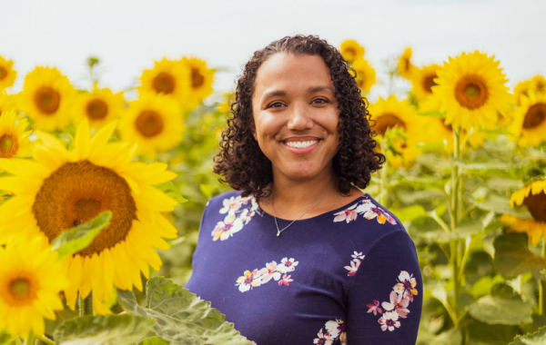 person in a sunflower field smiling