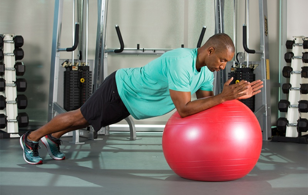 person balancing in plank position on a exercise ball