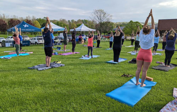 People standing outdoors doing a yoga post