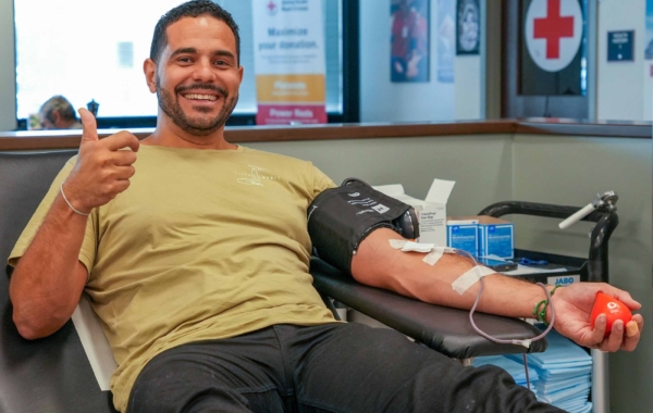 person sitting in a reclining chair giving blood and giving a thumbs up