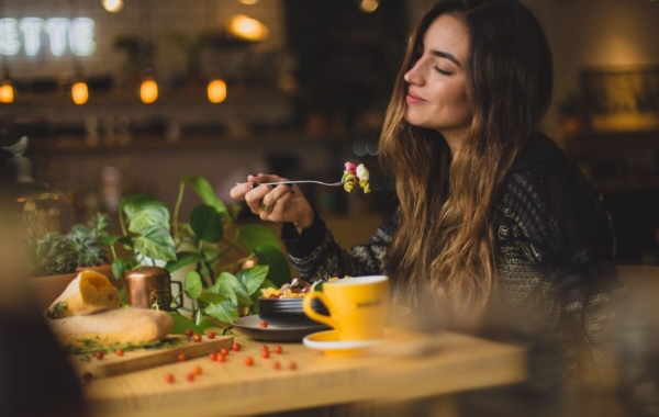 person at a wooden table with a fork