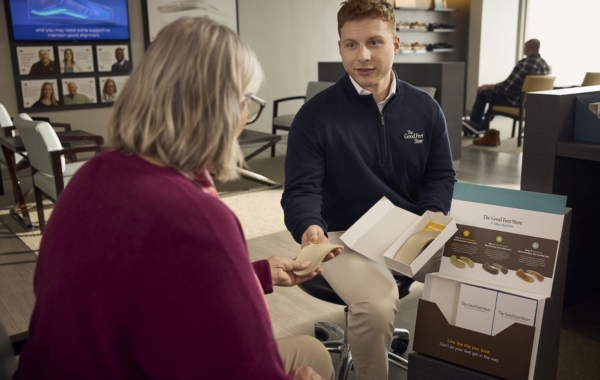 person handing shoe insert to another person